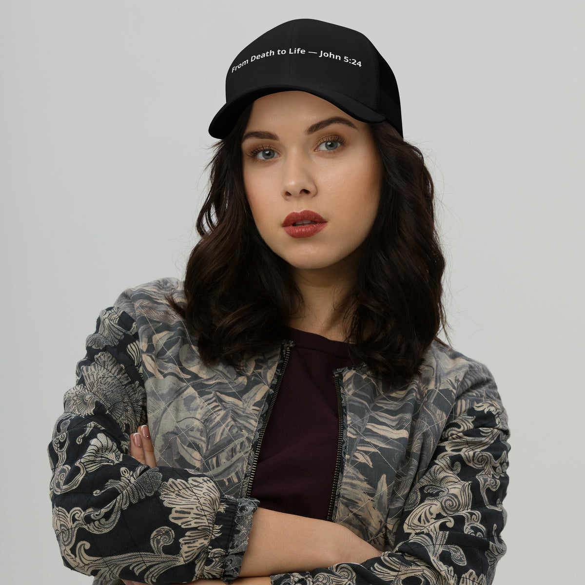 Black retro trucker hat with "From Death to Life" and John 5:24 scripture, featuring a classic mesh back and adjustable strap.