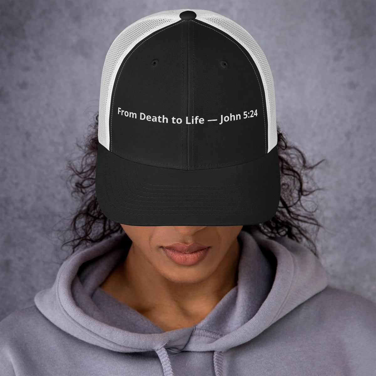 Black and white From Death to Life Trucker Hat featuring John 5:24 scripture, styled as a retro Christian-themed hat.